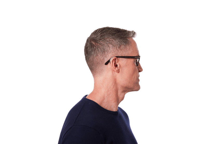 Side profile of a man wearing a slate BTE hearing aid behind his ear