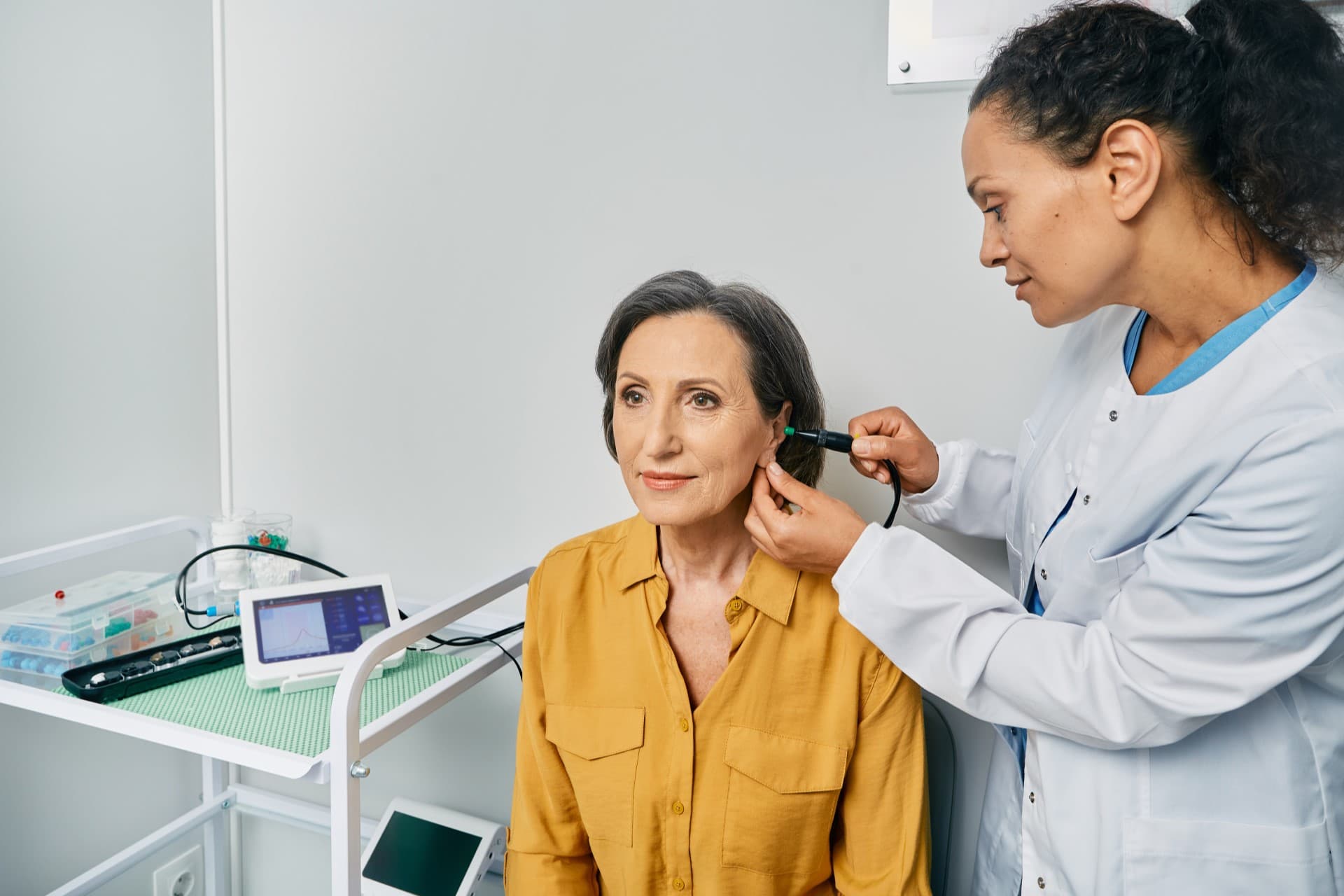 Hearing specialist examining a patient's ear with an otoscope