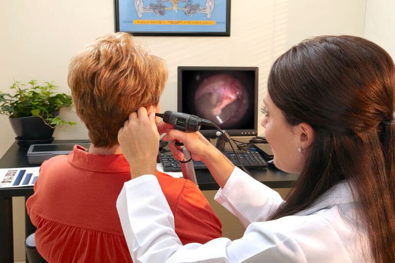 A Livingston hearing specialist performing a video otoscopy ear canal inspection for a patient