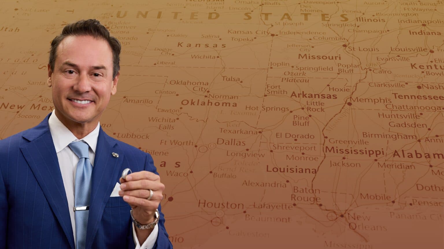 Richard Davila II holding a hearing aid in front of a US map